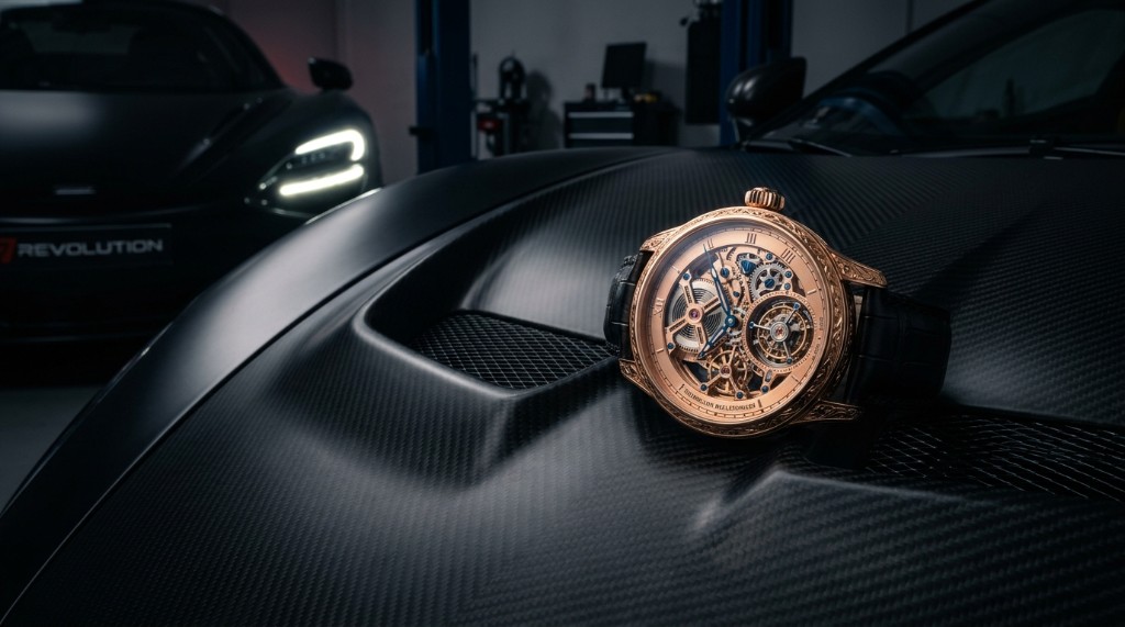 Rose-gold tourbillon on carbon bodywork with a hypercar in the bay